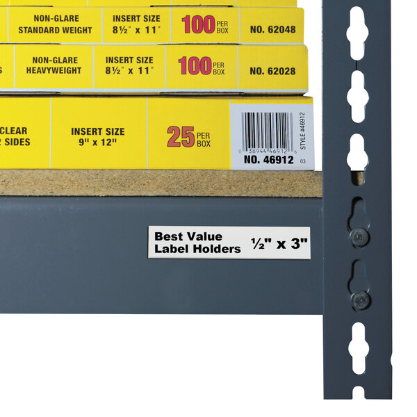 A shelf with a stack of yellow boxes labeled with C-Line 3" x 1/2" Clear Label Holders.