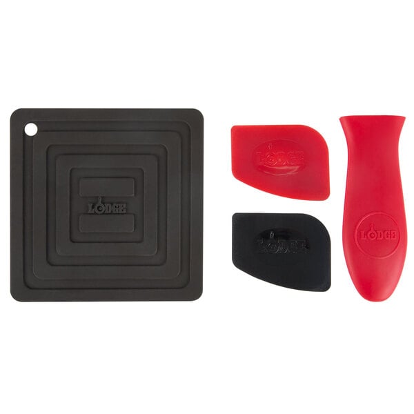 A Lodge 7-piece cast iron skillet set with red and black silicone handle holders and trivet and two pan scrapers.