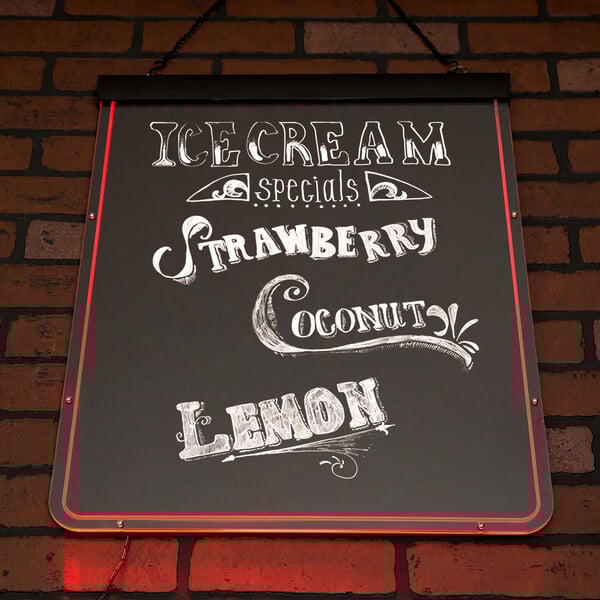 A white Aarco lighted write-on markerboard on a brick wall with neon writing that reads "Ice Cream, Strawberry, Lemonade"