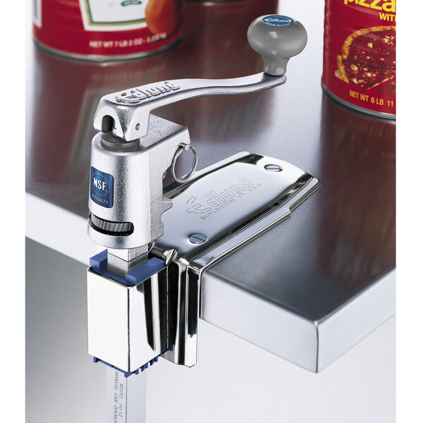 A stainless steel Edlund can opener base on a counter top with a can of pizza sauce.