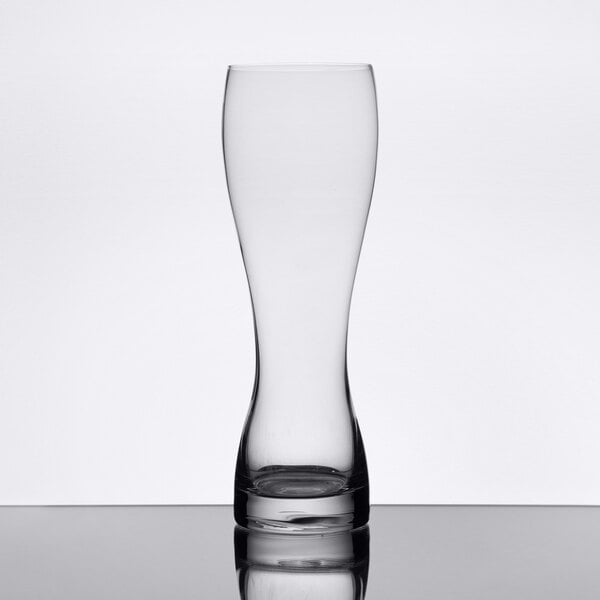 A close up of a clear Stolzle wheat beer glass on a table.