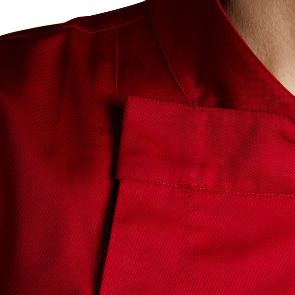 A close up of a Chef Revival tomato red chef jacket with short sleeves and hidden snap buttons.