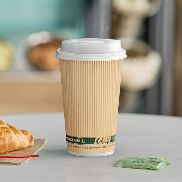 A close-up of an EcoChoice kraft paper coffee cup with a croissant on a table.