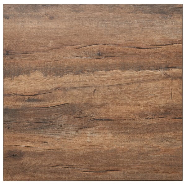 A close up of a knotty pine wood table top with a brown stain.