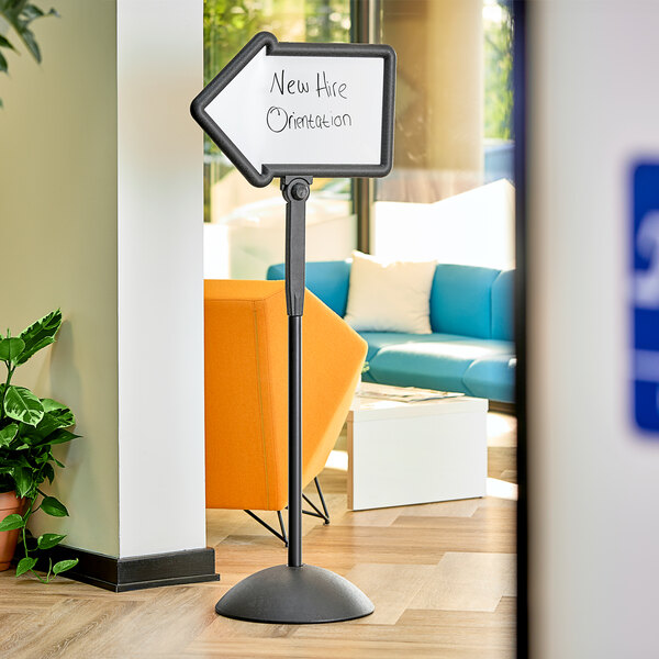 A Safco double sided magnetic/dry erase arrow sign with a black frame on a white surface.