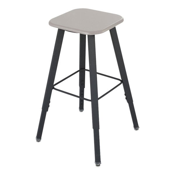 A beige and black Safco AlphaBetter adjustable-height student stool with a square seat.