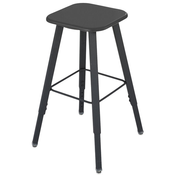 A black Safco AlphaBetter adjustable-height student stool with legs and a seat.