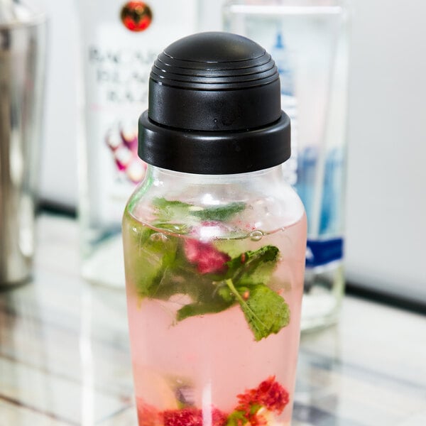 A Libbey glass bottle with a black shaker cap filled with a drink.