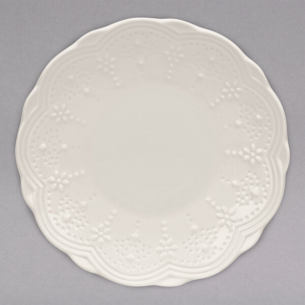 A white 10 Strawberry Street Valentina bread and butter plate with a flower pattern.