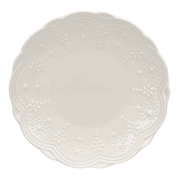 A white bone china bread and butter plate with a scalloped edge and embossed floral pattern.