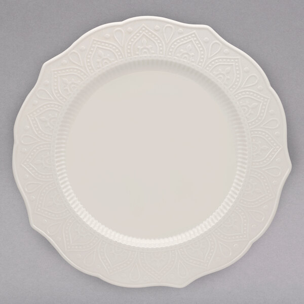 A 10 Strawberry Street white porcelain dinner plate with a decorative design.