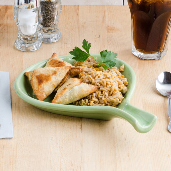 A Tuxton fry pan server with food on a table.