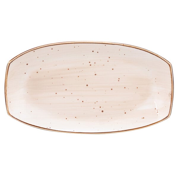 a white oval plate with brown specks on it