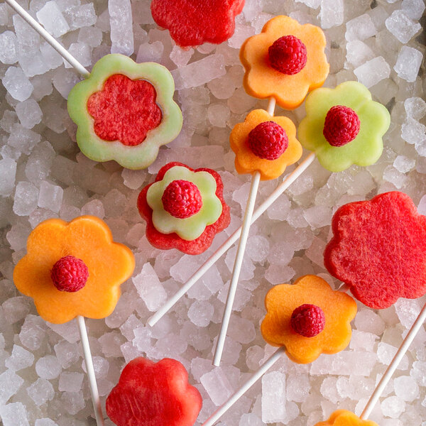 A fruit stick with a chocolate rose on top.