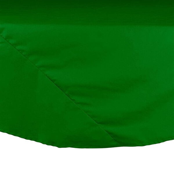 A green Intedge round table cover on a table.