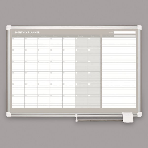 A white rectangular MasterVision dry erase board with a monthly calendar.