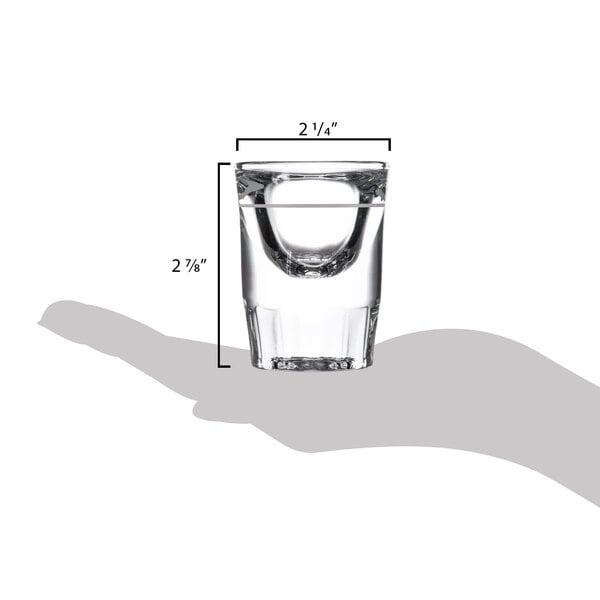 A hand holding a Libbey fluted shot glass with a .5 oz. pour line.