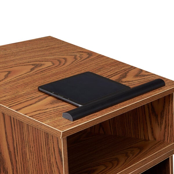 A black tablet on a wooden Oklahoma Sound tabletop host stand.