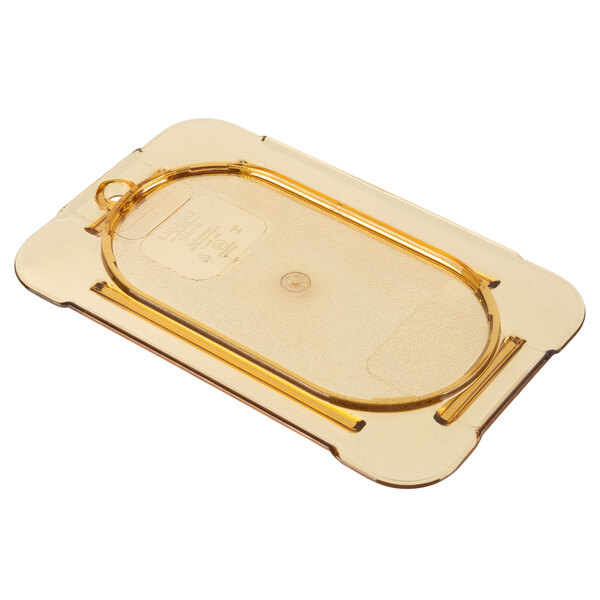 A Carlisle amber plastic lid on a plastic food pan.