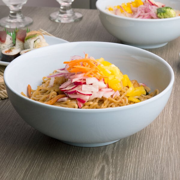 Two bowls of Thunder Group Blue Jade melamine soup with noodles and vegetables on a table.