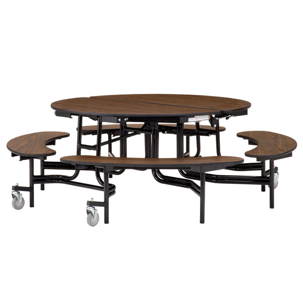 A National Public Seating round wooden cafeteria table with attached benches on wheels.