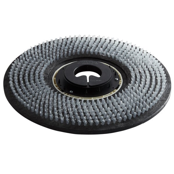 A circular metal Minuteman pad driver with bristles on it.