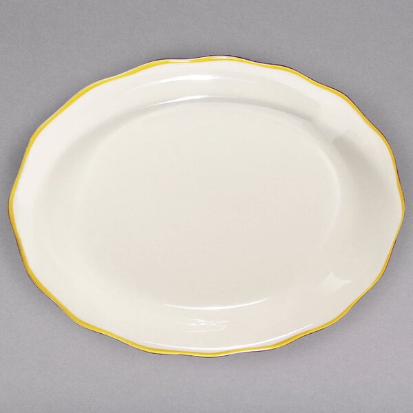 A CAC ivory china platter with scalloped edges and gold trim.