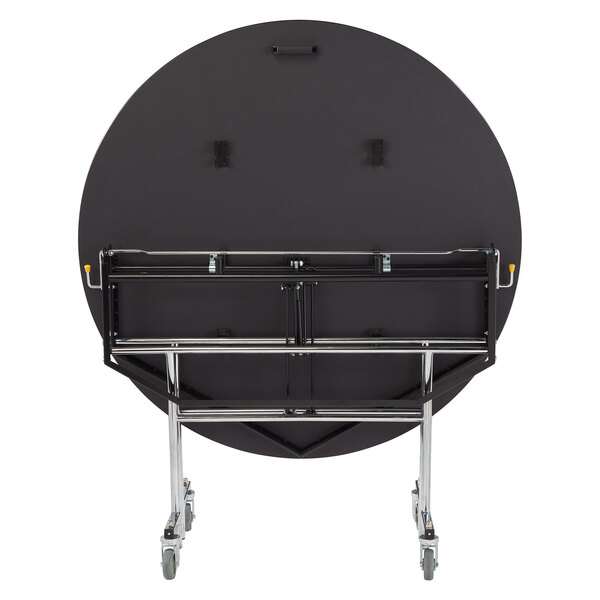 A black round National Public Seating cafeteria table with a metal frame on wheels.