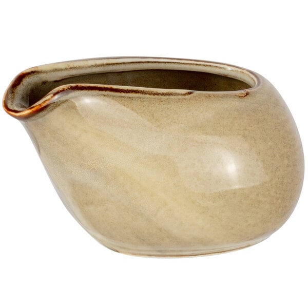 A cream colored Bon Chef porcelain creamer with a handle.