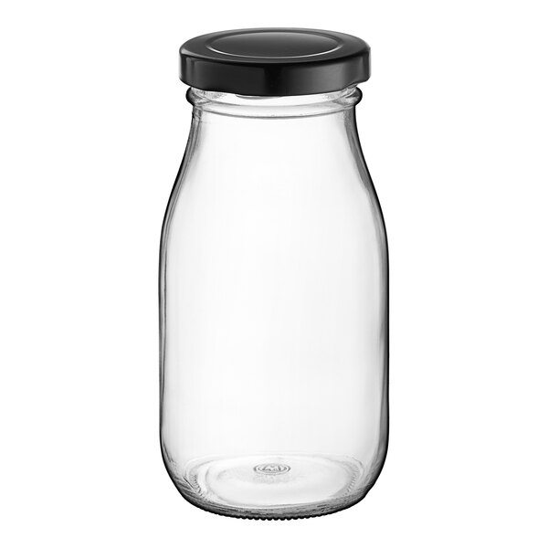 An Acopa clear glass milk bottle with a black lid.