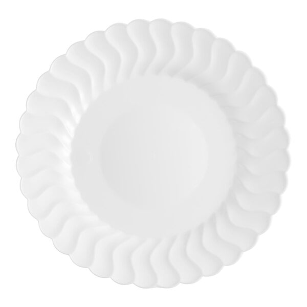 A close-up of a white Fineline Flairware plastic plate with wavy edges.