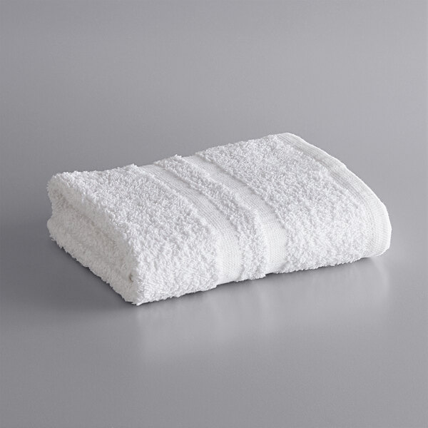 A rolled white Lavex hand towel on a gray surface.