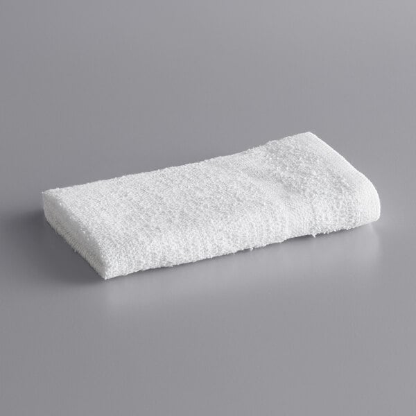 A white Lavex cotton wash cloth on a gray surface.