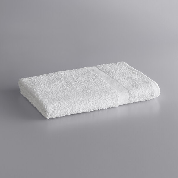 A white Lavex Economy bath towel on a gray surface.