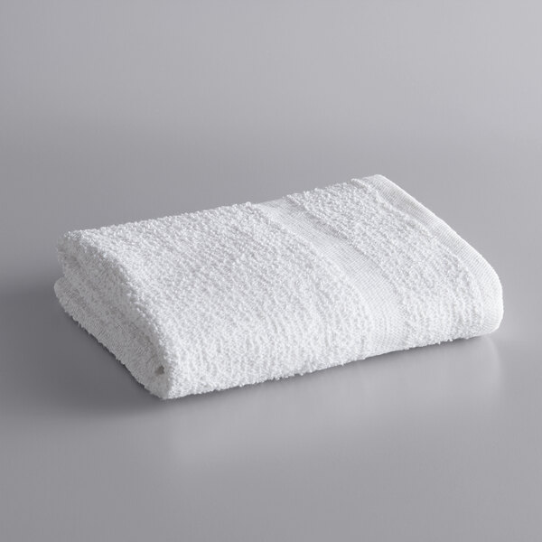 A rolled white Lavex hand towel on a gray surface.