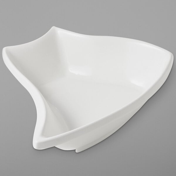 A white Bon Chef curved serving bowl on a gray surface.