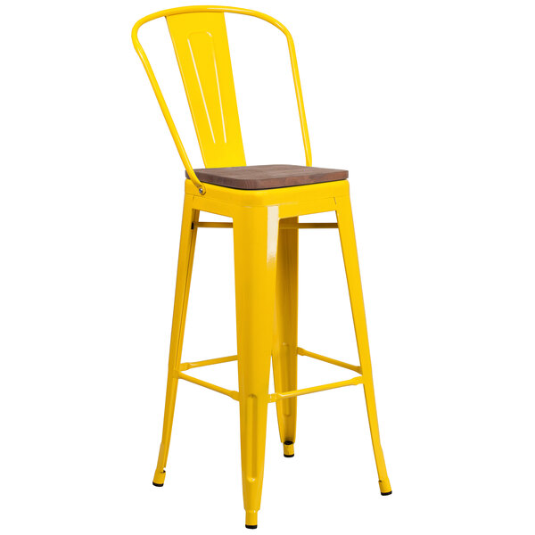 A yellow bar stool with a wooden seat.