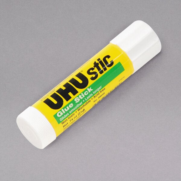 A yellow and white tube of UHU Permanent Clear Glue Stick with black text.