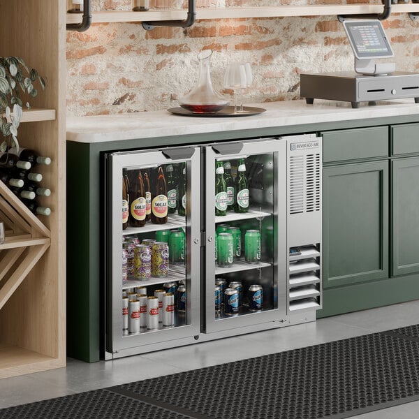 A stainless steel underbar height glass door back bar refrigerator filled with various beverages.