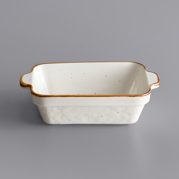 A white rectangular stoneware casserole dish with brown specks.
