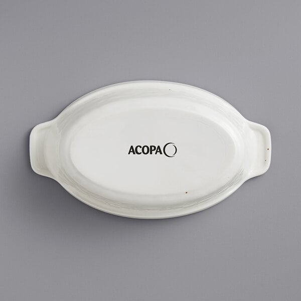 An Acopa white stoneware oval baker with black text reading "Acopa" on the bottom.