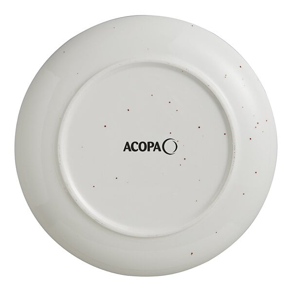 An Acopa Keystone vanilla bean stoneware coupe plate with black speckled specks.