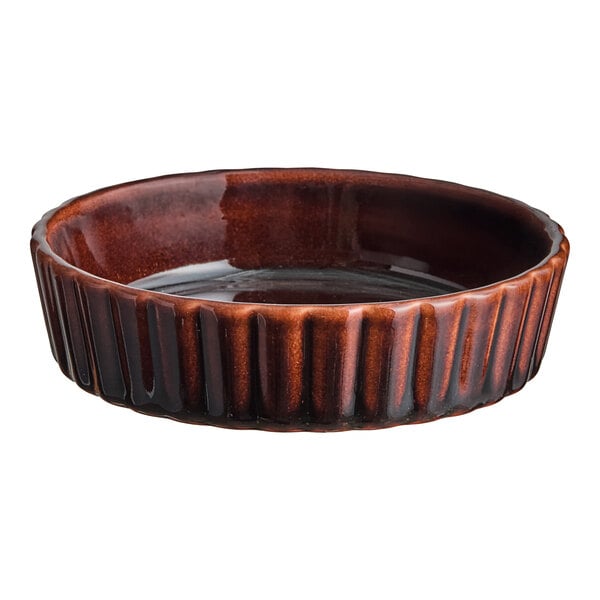 A brown stoneware souffle or creme brulee dish with a ribbed exterior.