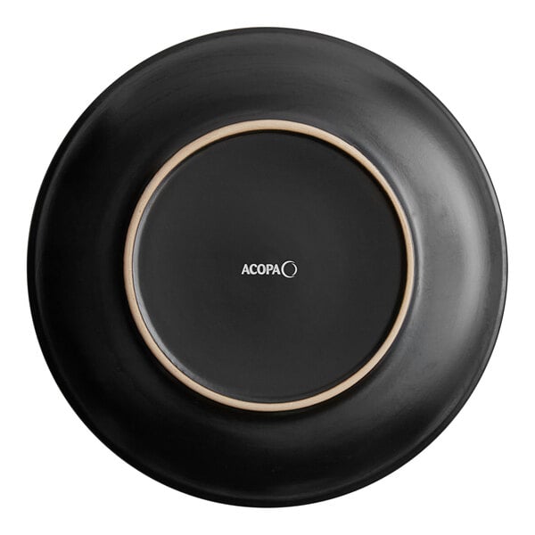 A black Acopa stoneware coupe plate with a white circle on it.