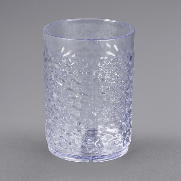 A close-up of a Carlisle clear plastic tumbler with a textured surface.
