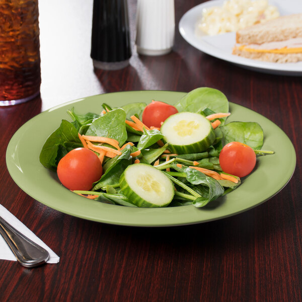 A plate of salad with tomatoes, cucumbers, and carrots in a GET Diamond Harvest avocado melamine bowl.
