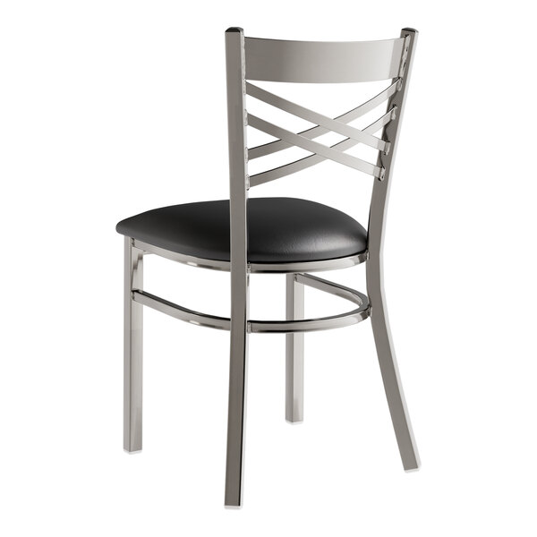 A metal cross back chair with a padded black seat and a clear coat finish.