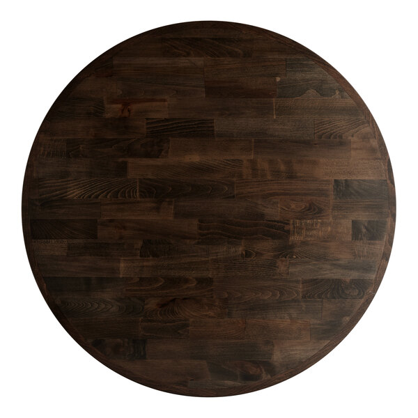 A Lancaster Table & Seating round wooden table with an espresso finish on a cast iron base.