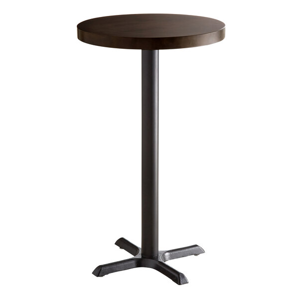 A Lancaster Table & Seating round wood table with espresso finish and cast iron base plate.