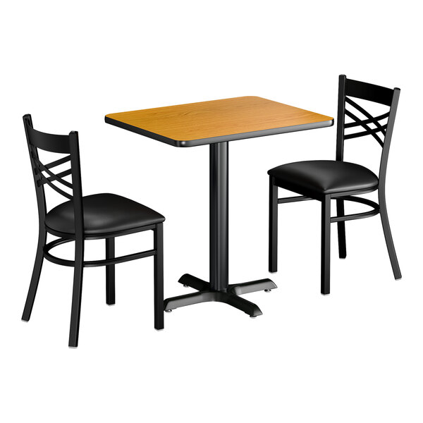 A standard height dining set with a rectangular wood-finish table and two black crossback chairs.